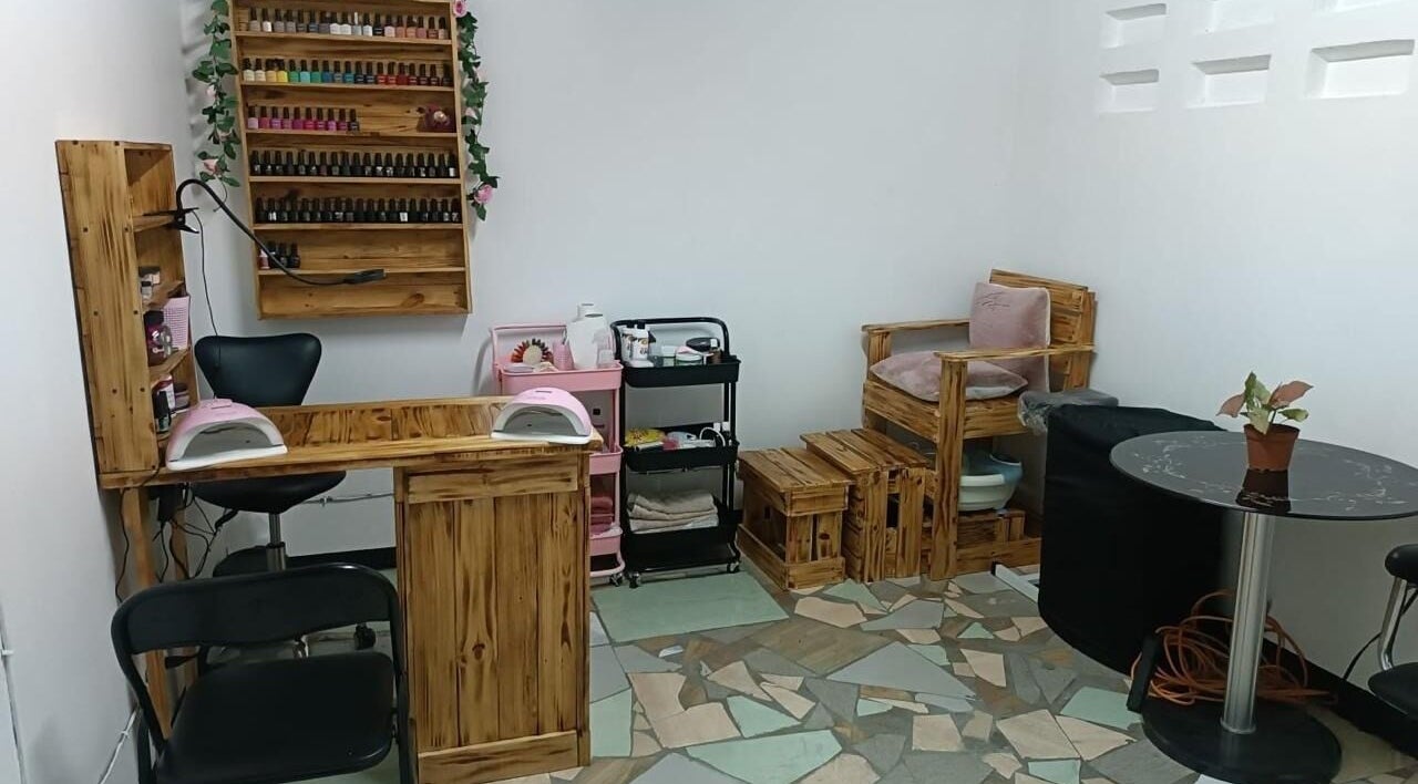 Cozy nail salon interior at Ongles par Flor, Paramaribo, SR showcasing wooden furniture and nail polish display.