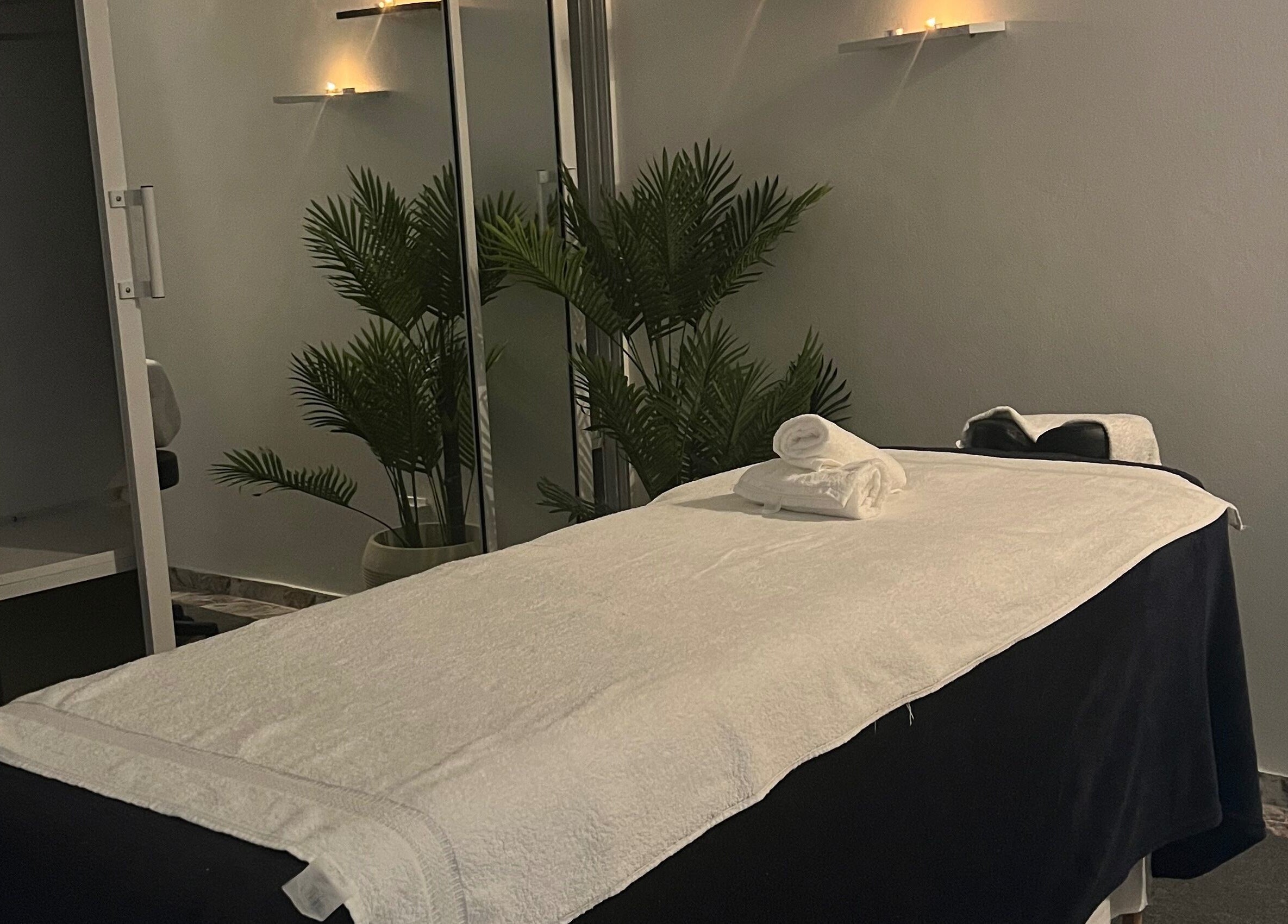 Relaxing massage room at Caya Spa, Santiago De Los Caballeros, Santiago, DO with soft candlelight.