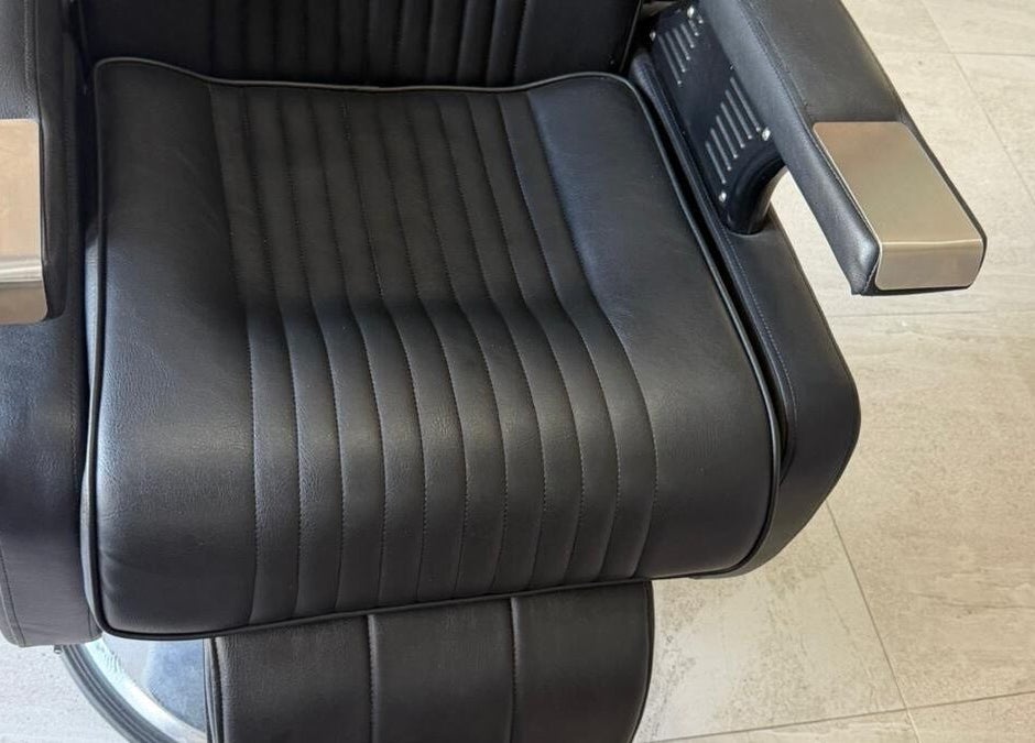 Luxurious black barber chair at Billionaire Barber, Ruby, Saint Philip, BB. Modern comfort and style.