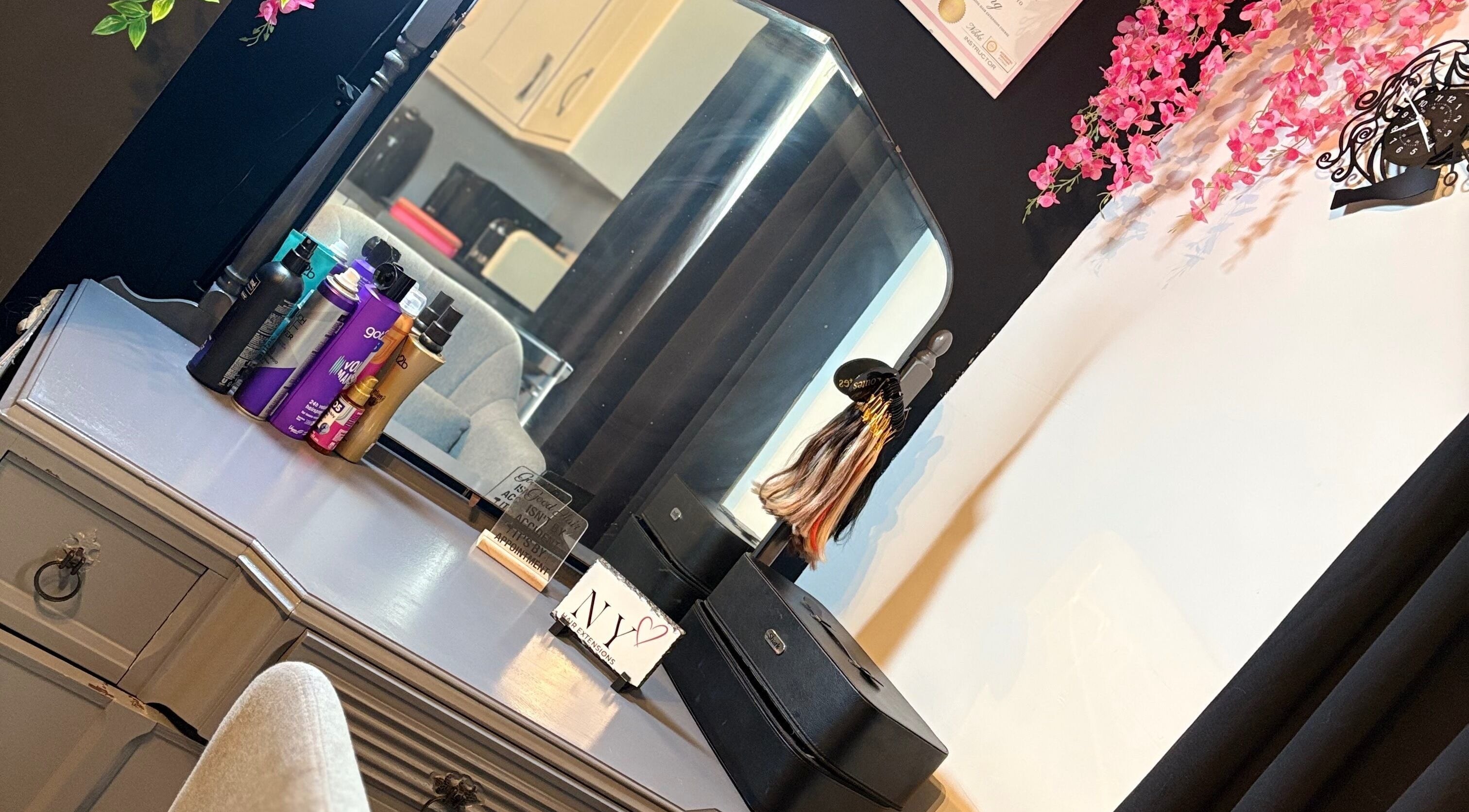 Elegant beauty station at NYHairextensions, Carlisle, England, GB, featuring hair products and pink flowers.