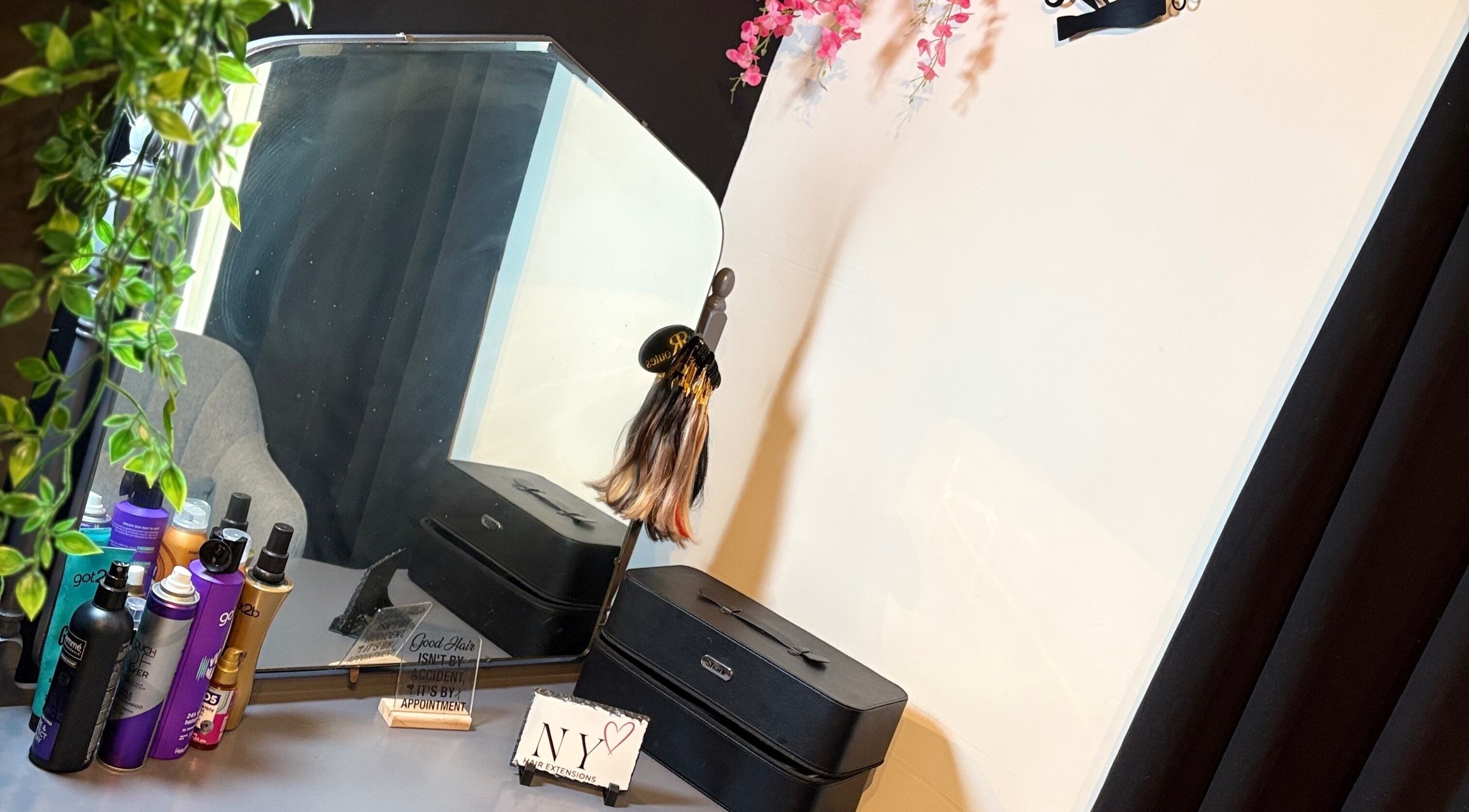 Beauty station at NYHairextensions, Carlisle, England, GB with styling products and mirror decor.