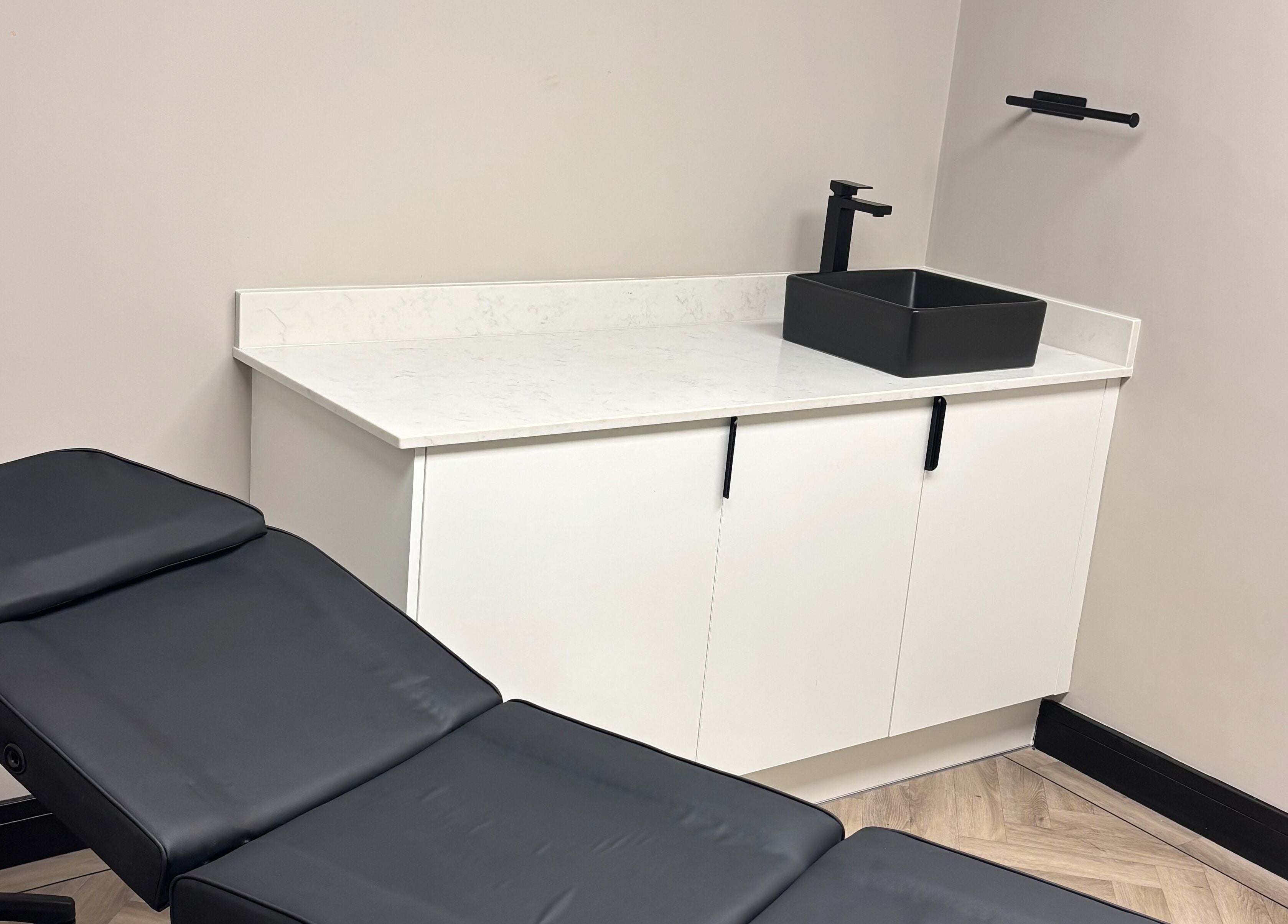 Sleek beauty treatment room at Soft Touch Beauty, Framwellgate Moor, England, GB with a black chair and modern sink.