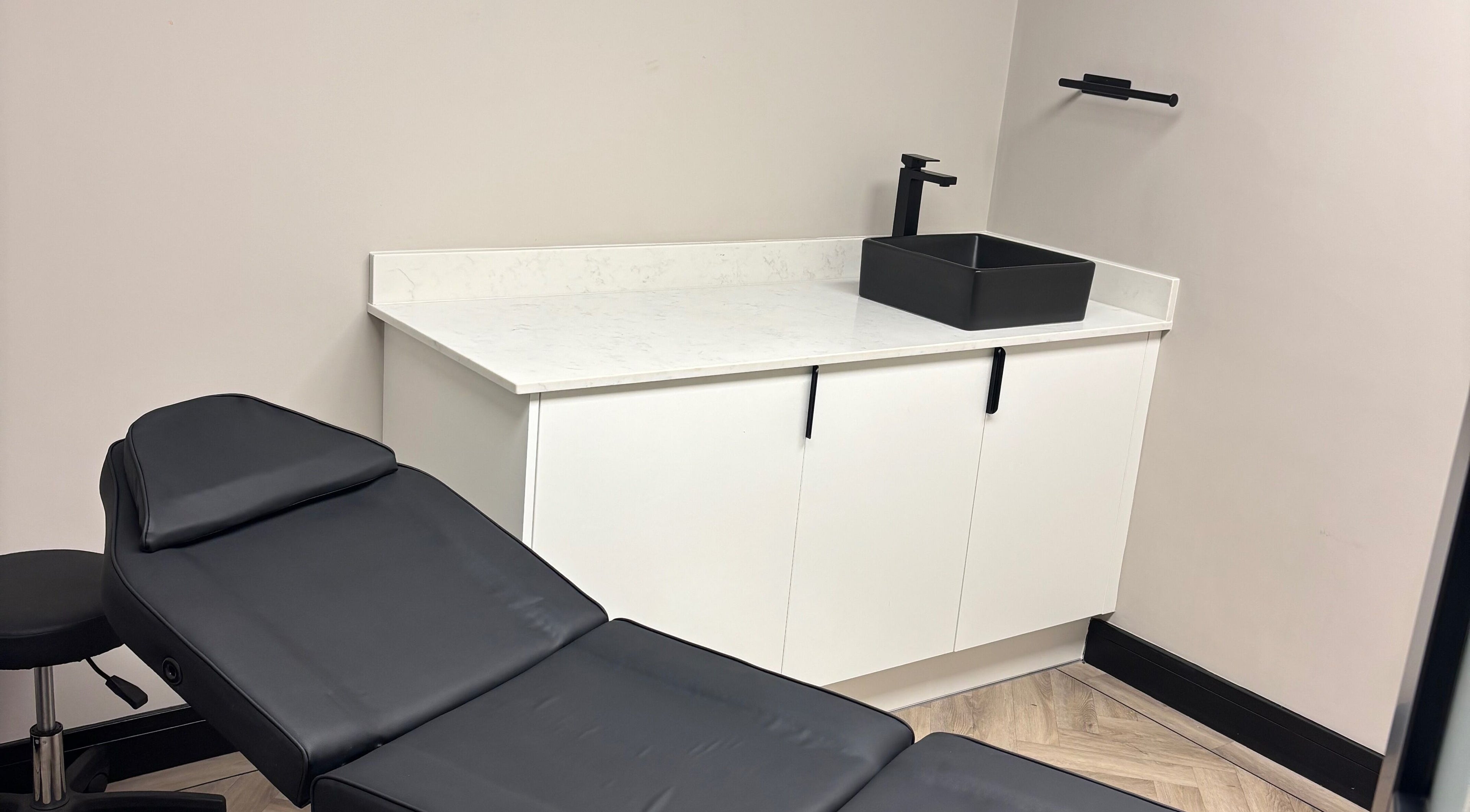 Sleek beauty treatment room at Soft Touch Beauty, Framwellgate Moor, England, GB with a black chair and modern sink.