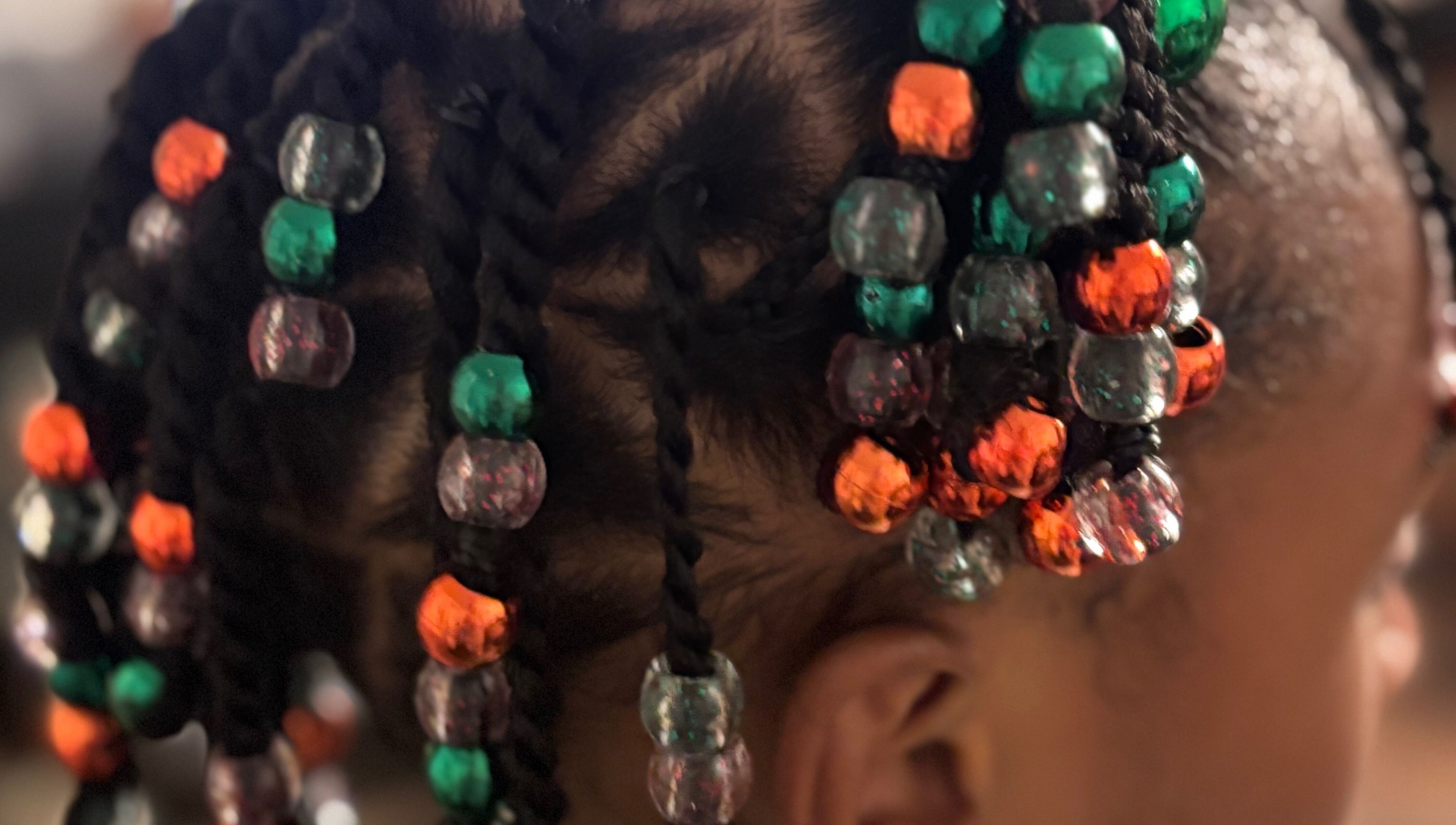 Close-up of colorful beaded braids at Hair Love by Taryn, Lakeland, Florida, US, showcasing creative hairstyle.