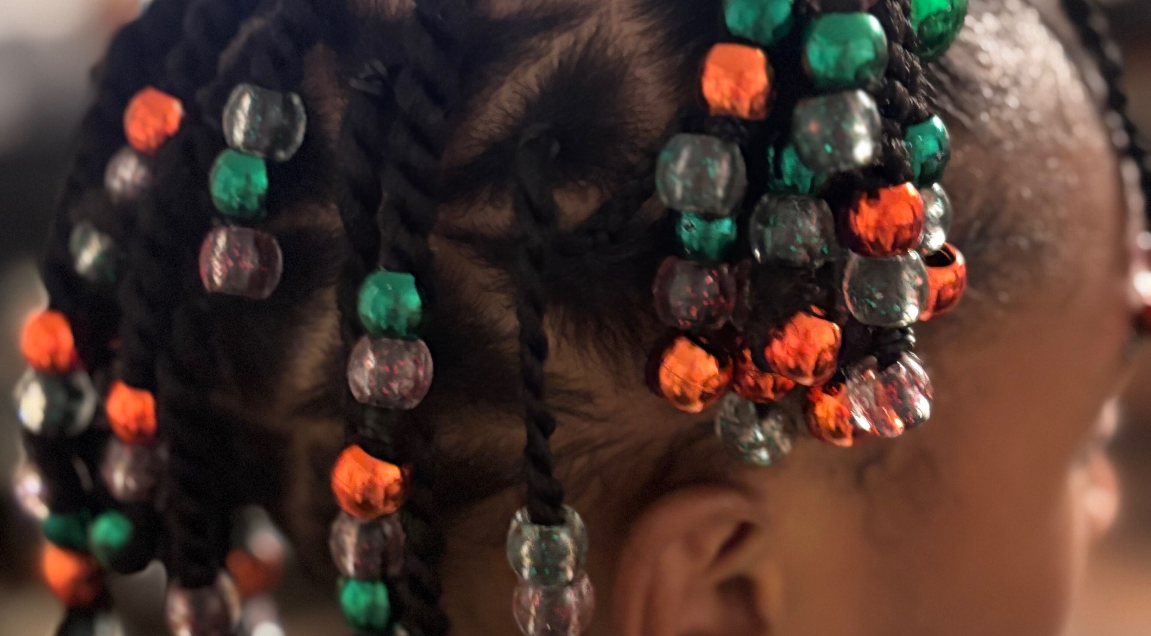 Close-up of colorful beaded braids at Hair Love by Taryn, Lakeland, Florida, US, showcasing creative hairstyle.
