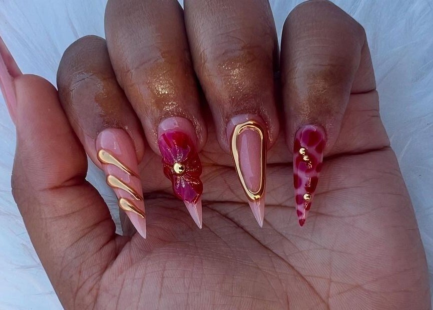Stylish nail art with red and gold accents at The Beauty Booth, Bloemfontein, Free State, ZA.