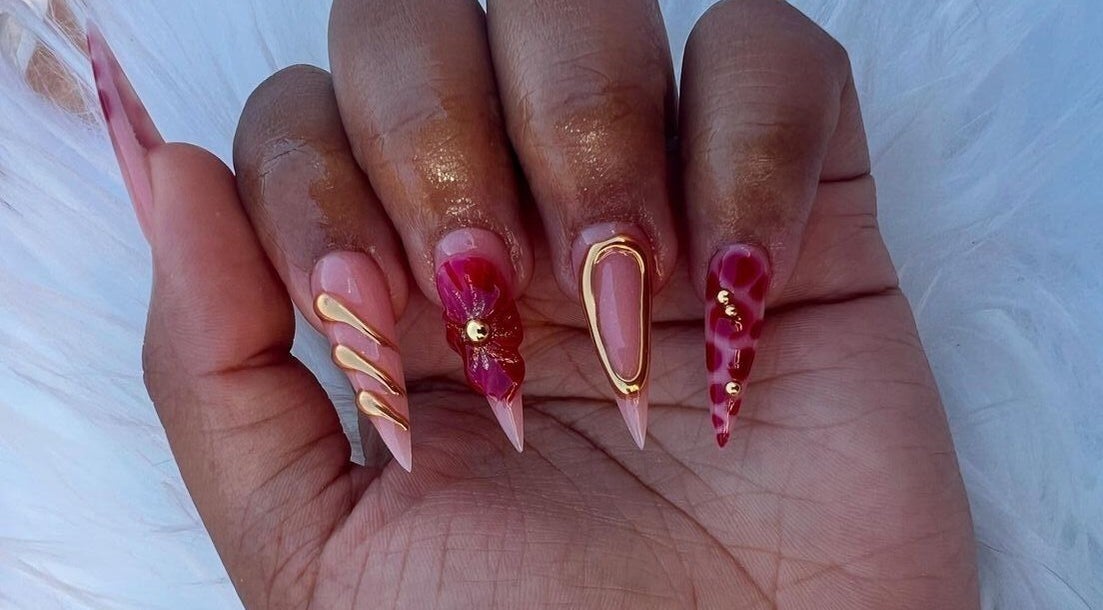 Stylish nail art with red and gold accents at The Beauty Booth, Bloemfontein, Free State, ZA.