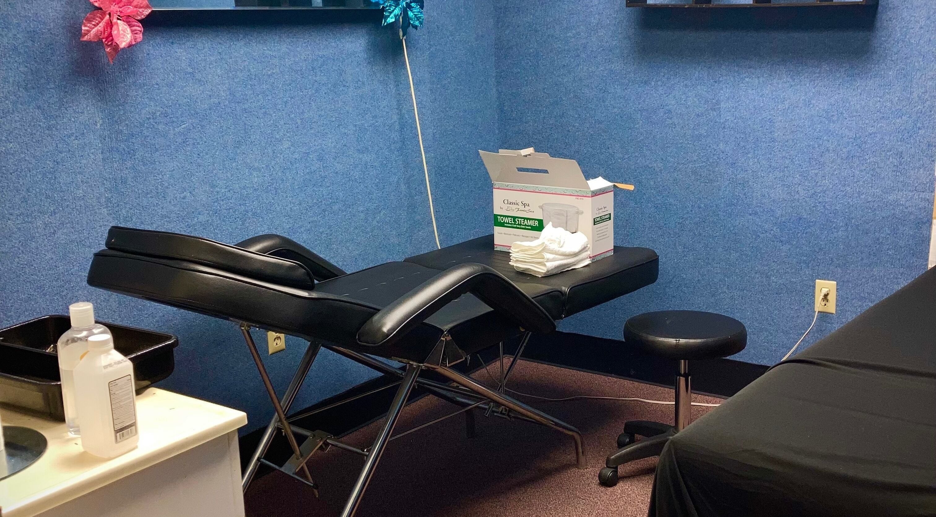 Relaxing spa treatment room at Hairfanaticboutique Llc, Columbia, South Carolina, US, showcasing comfy massage table.