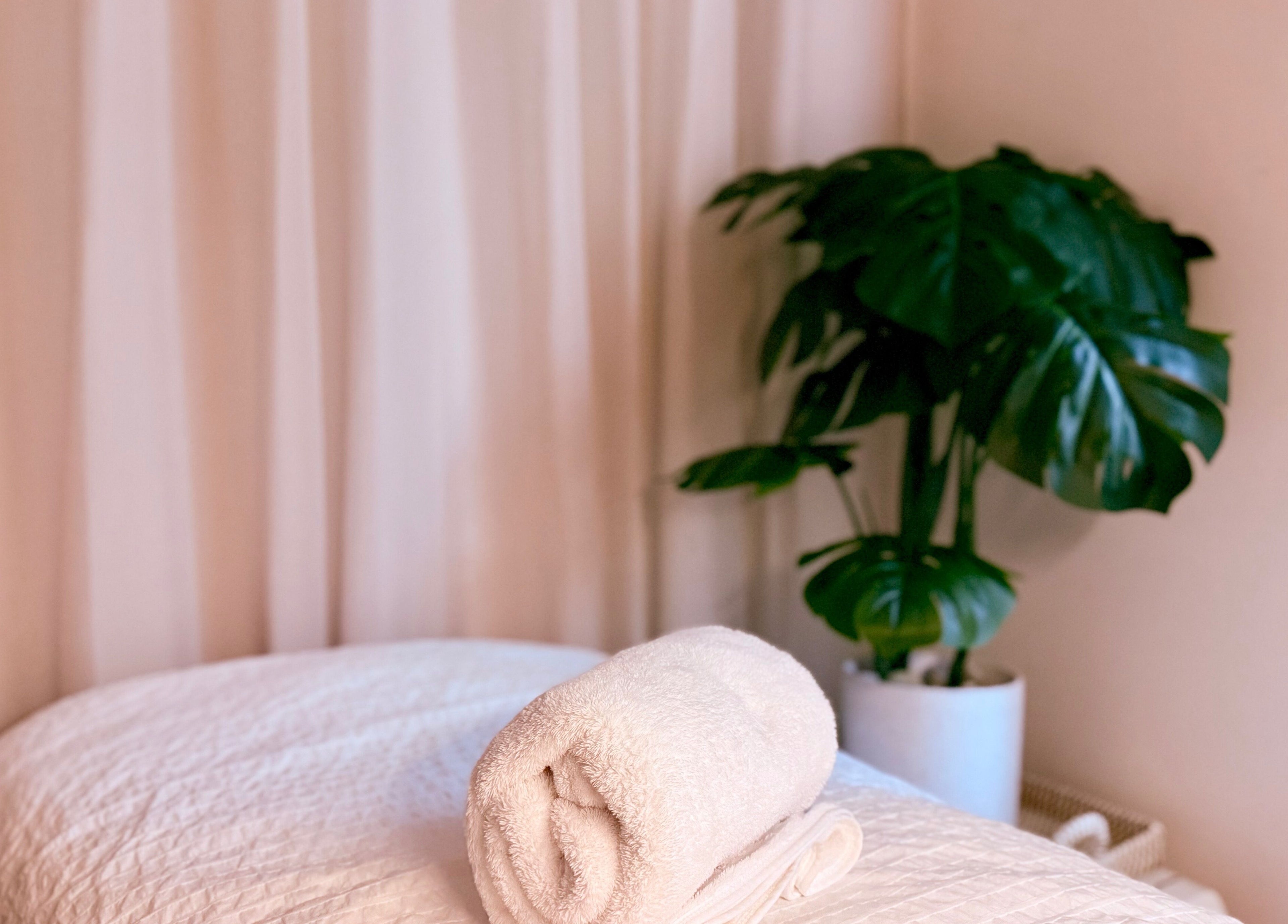 Serene massage table setup at M.N.M Beauty Bar in Roselands, New South Wales, AU with lush greenery.