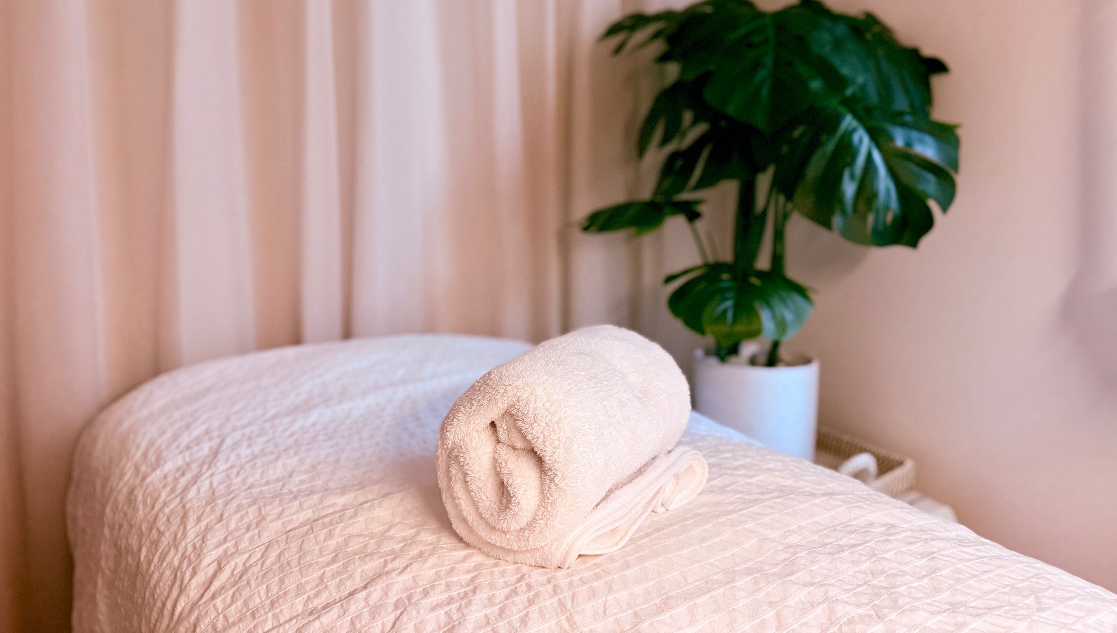 Relaxing massage table with rolled towel at M.N.M Beauty Bar in Roselands, New South Wales, AU.