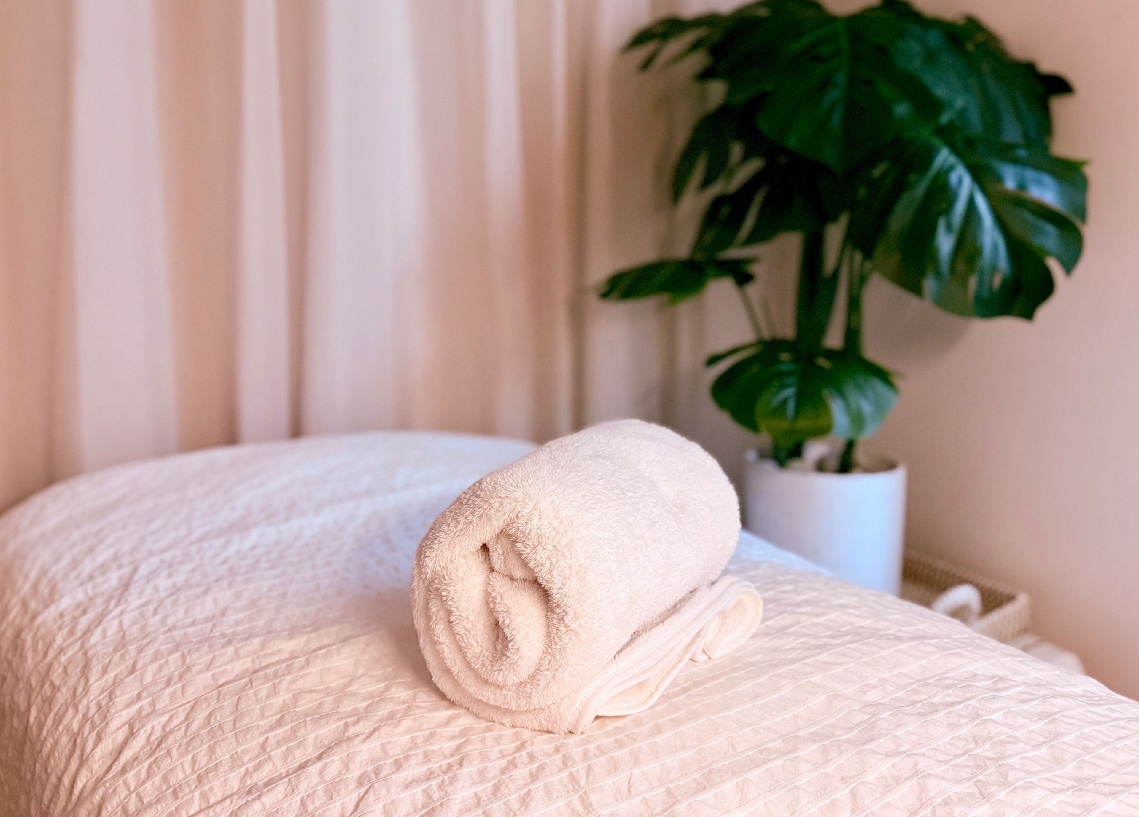 Relaxing massage table with rolled towel at M.N.M Beauty Bar in Roselands, New South Wales, AU.
