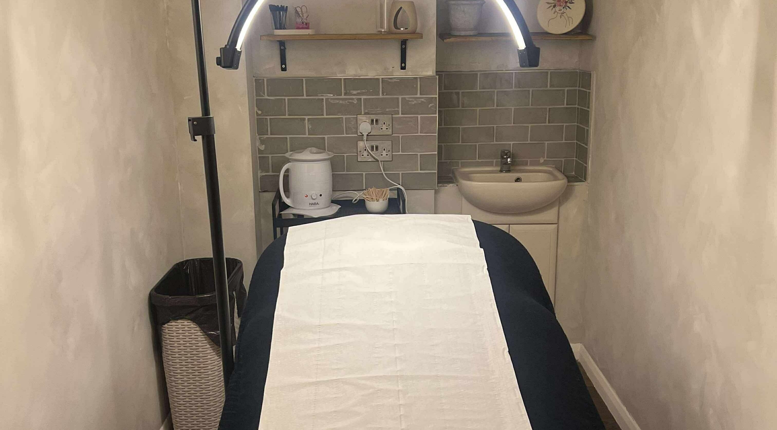 Serene treatment room at TL SkinStudio, Devizes, England, GB with ambient lighting and a comfortable spa bed.