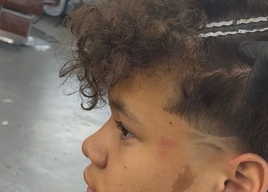 Close-up of a trendy haircut at davianscutzz in Dallas, Texas, US featuring curly hair and barber tools.