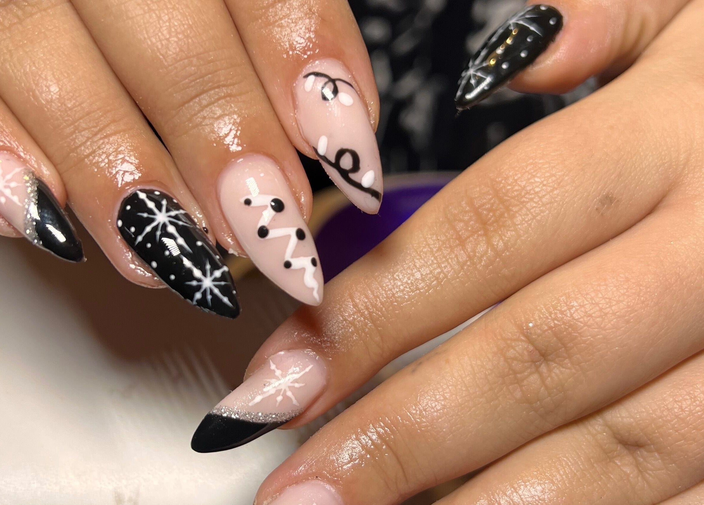 Stylish black and pink snowflake nail art at S25 in Saint Austell, England, GB.