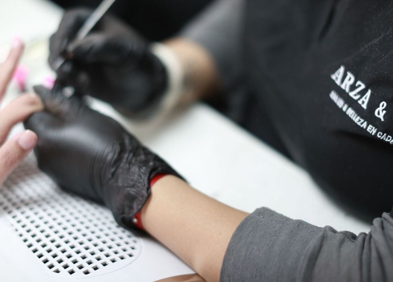 Nail artist at Arza & Co in Ciudad De México, MX expertly painting a client's nails.