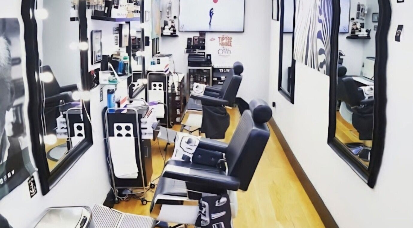 Interior of Gentlemen's Barbershop in New York, New York, US, featuring sleek barber chairs and modern decor.