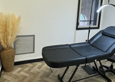 Stylish therapy room in Maia Emily Beauty, Derby, England, GB with a sleek black treatment bed.