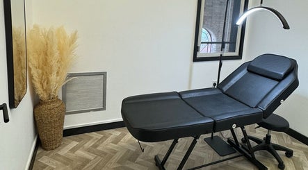 Stylish therapy room in Maia Emily Beauty, Derby, England, GB with a sleek black treatment bed.