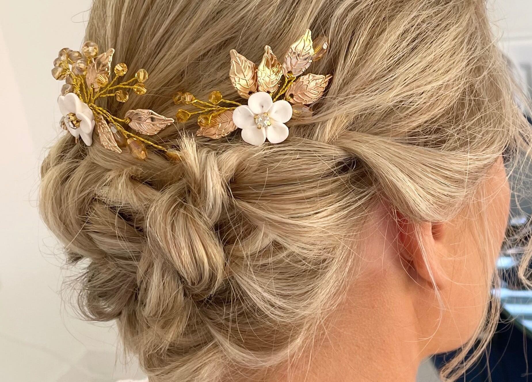 Elegant bridal updo with golden floral hairpiece at Josephine's Beauty, Thorrington, England, GB.