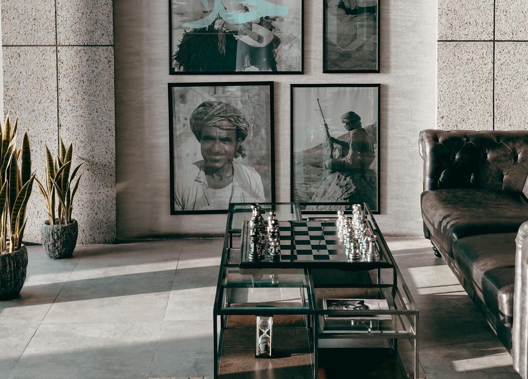 Chic lounge at 1948, Muscat, Muscat Governorate, OM with leather sofa, chess set, and framed art.