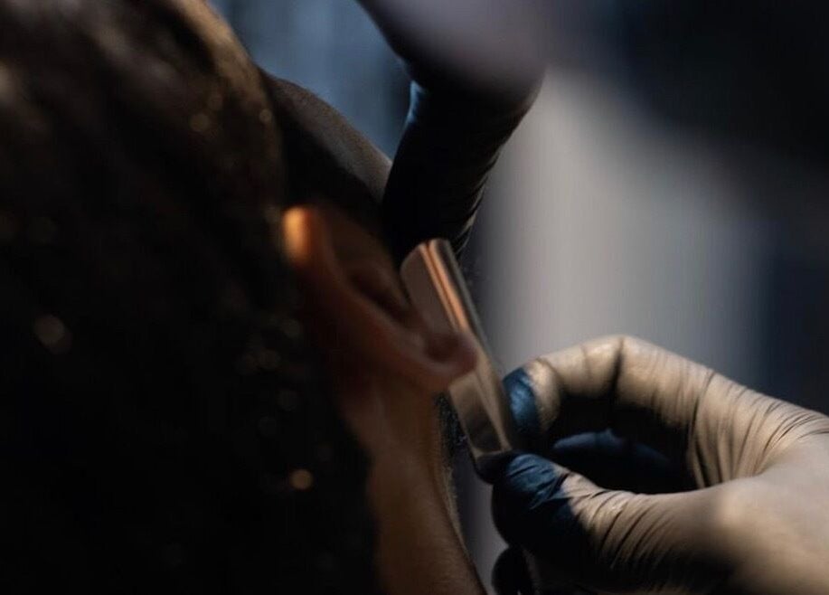 Detailed shaving service at 1948 in Muscat, Muscat Governorate, OM. Professional barber using a straight razor.