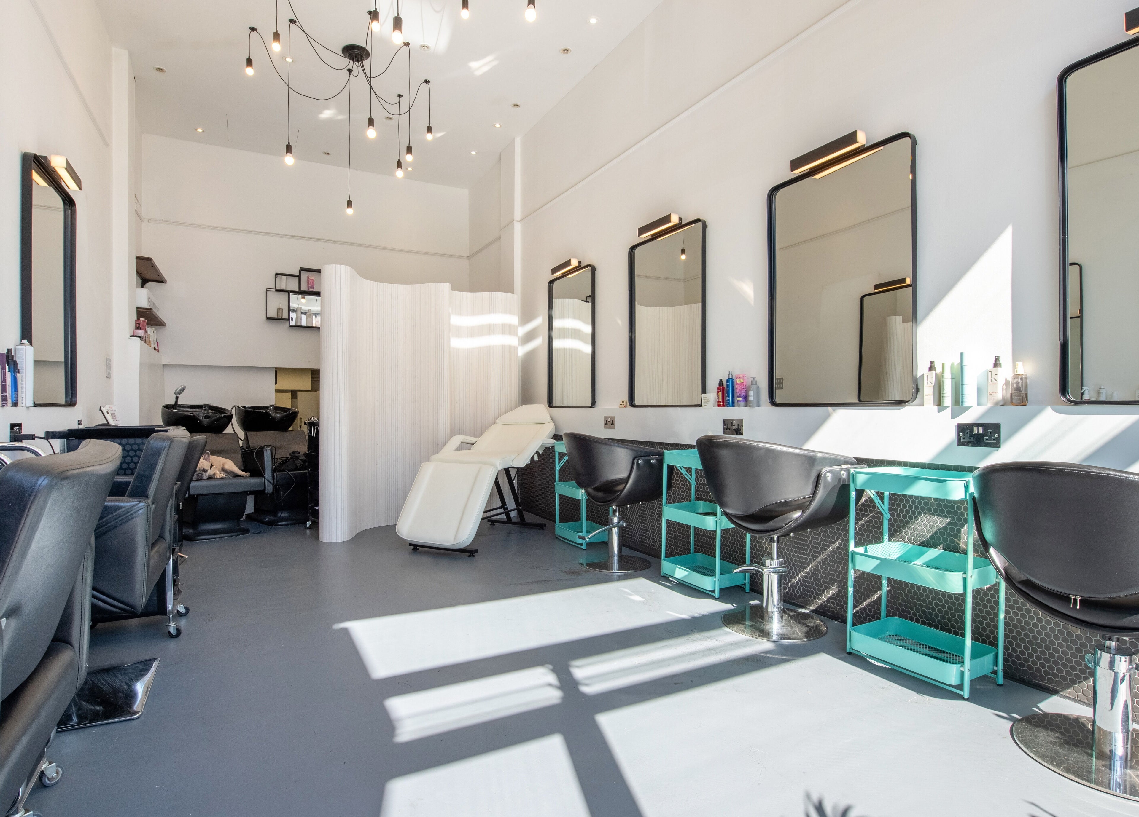 Bright, modern interior of Colour Hauz salon in London, England, GB with stylish chairs and mirrors.