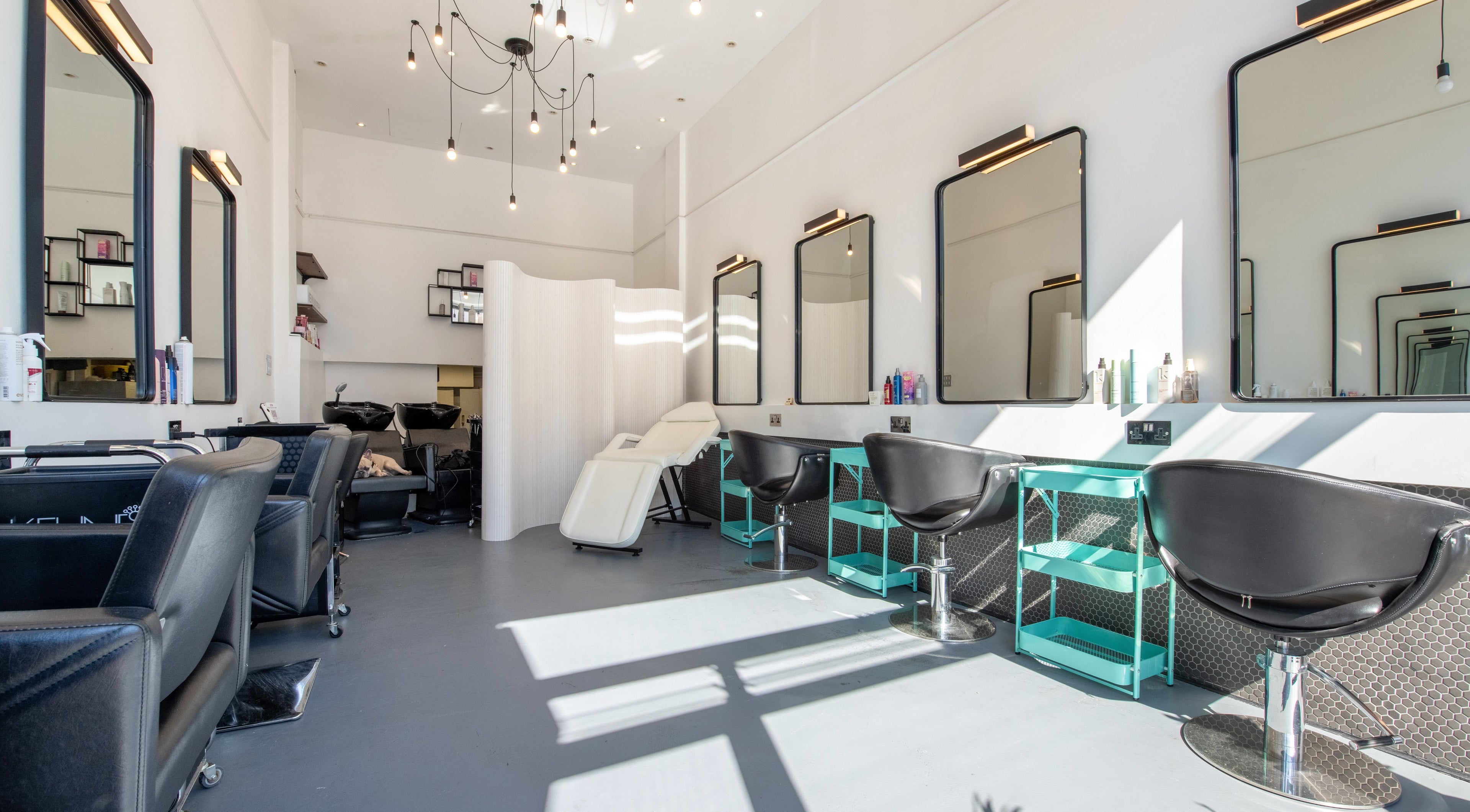 Bright, modern interior of Colour Hauz salon in London, England, GB with stylish chairs and mirrors.