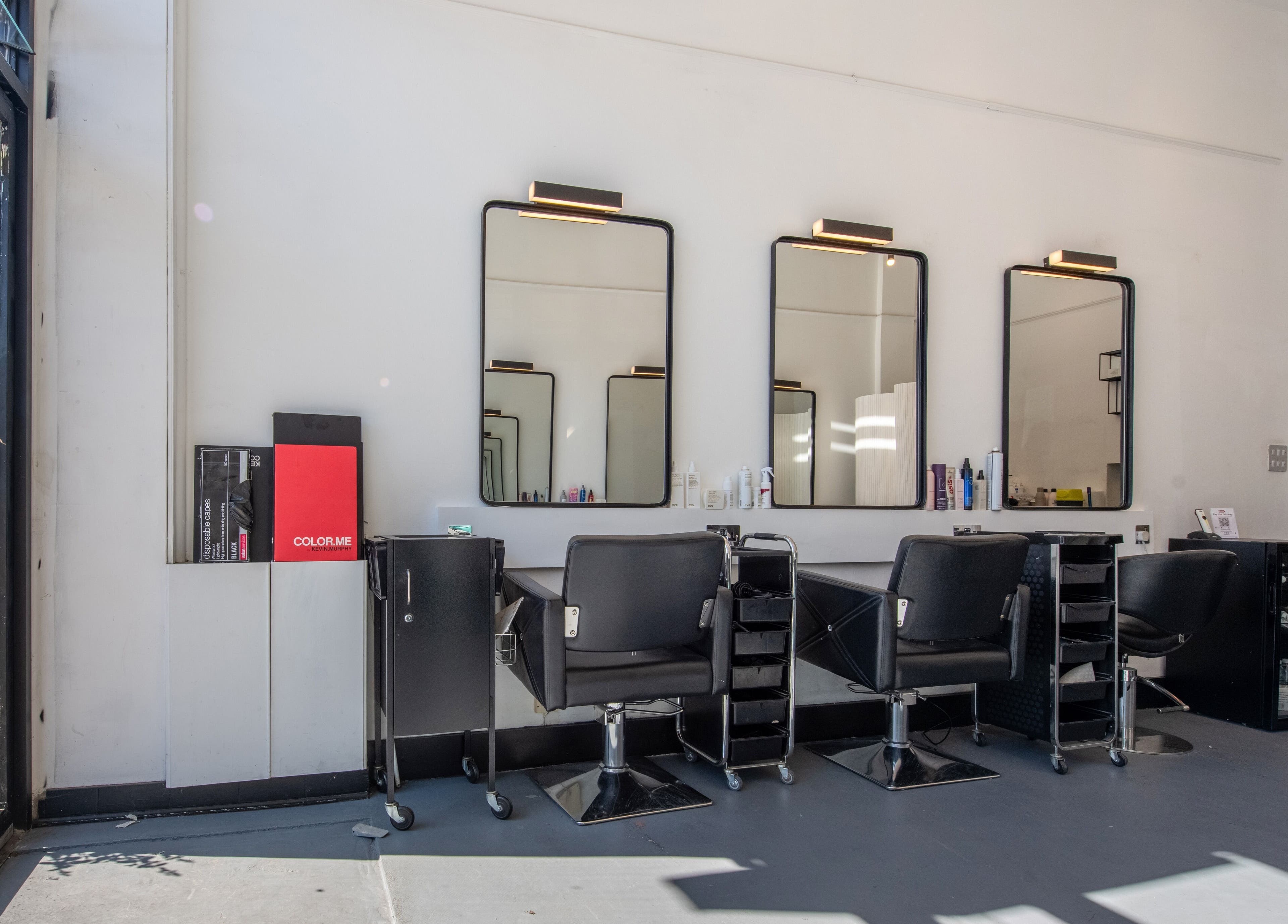 Modern salon interior at Colour Hauz, London, England, GB featuring styling stations and mirrors.