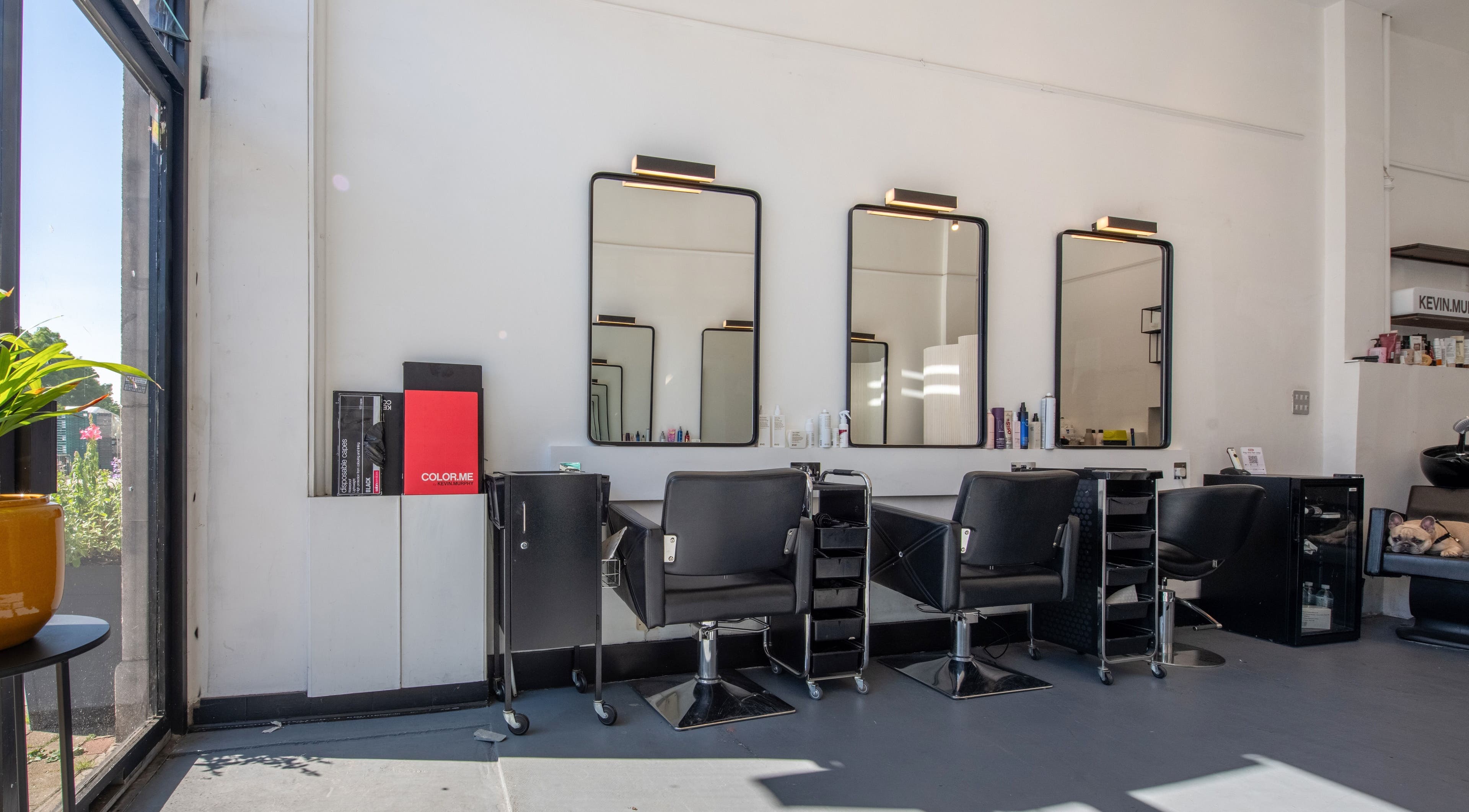 Modern salon interior at Colour Hauz, London, England, GB featuring styling stations and mirrors.