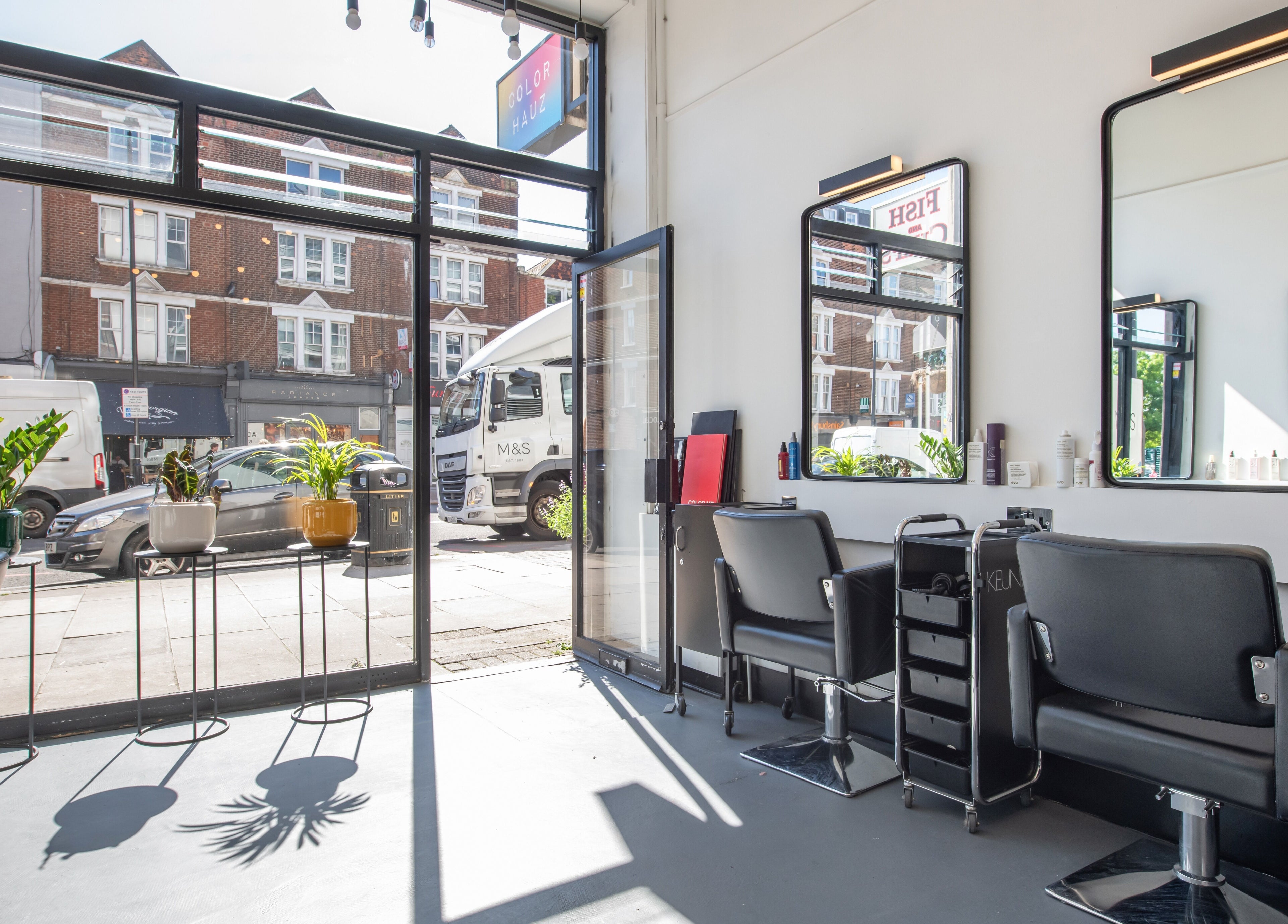 Modern salon interior at Colour Hauz, London, England, GB with stylish chairs and natural light.