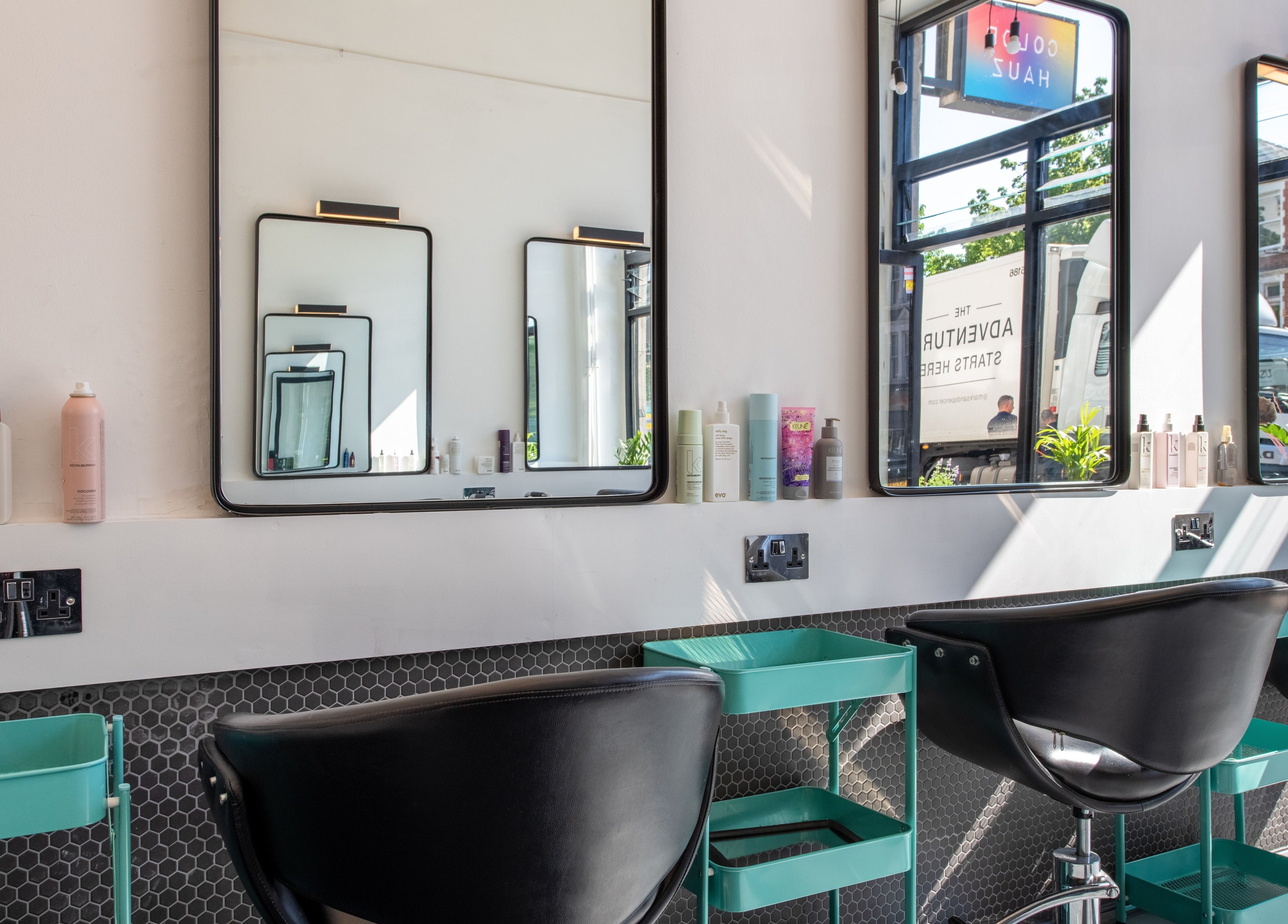 Stylish salon chairs and mirrors at Colour Hauz, London, England, GB, highlighting modern beauty amenities.