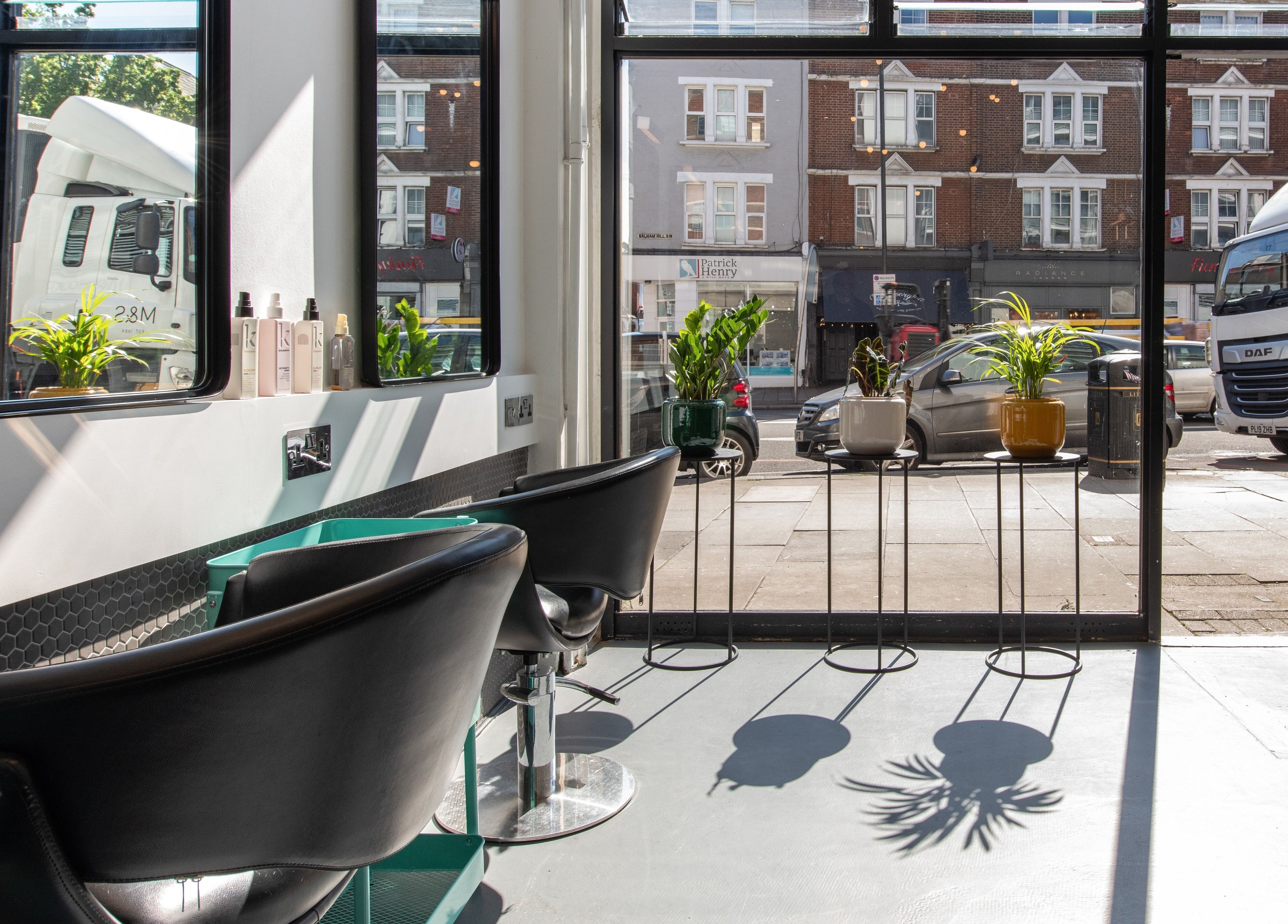 Inside view of Colour Hauz salon in London, England, GB, featuring modern chairs and large windows with street view.