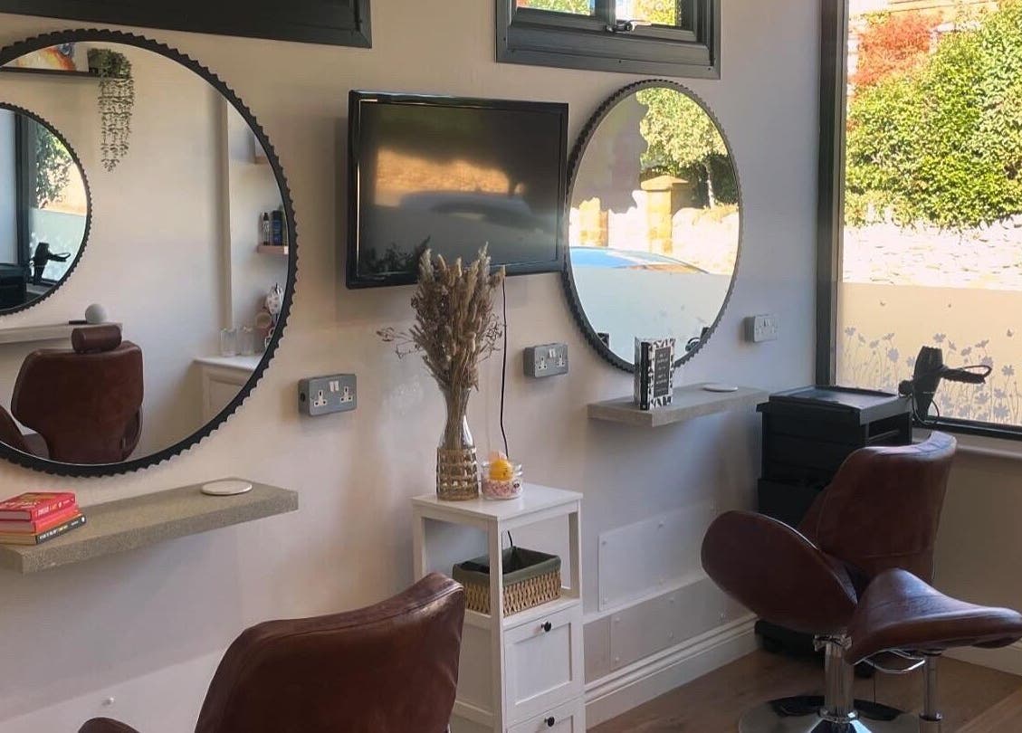 Elegant salon chairs and mirrors at Just Grace Hairdressing, Northampton, England, GB, showcasing modern decor.