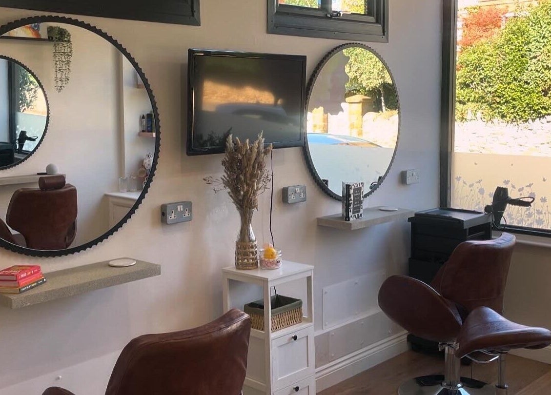Elegant salon chairs and mirrors at Just Grace Hairdressing, Northampton, England, GB, showcasing modern decor.