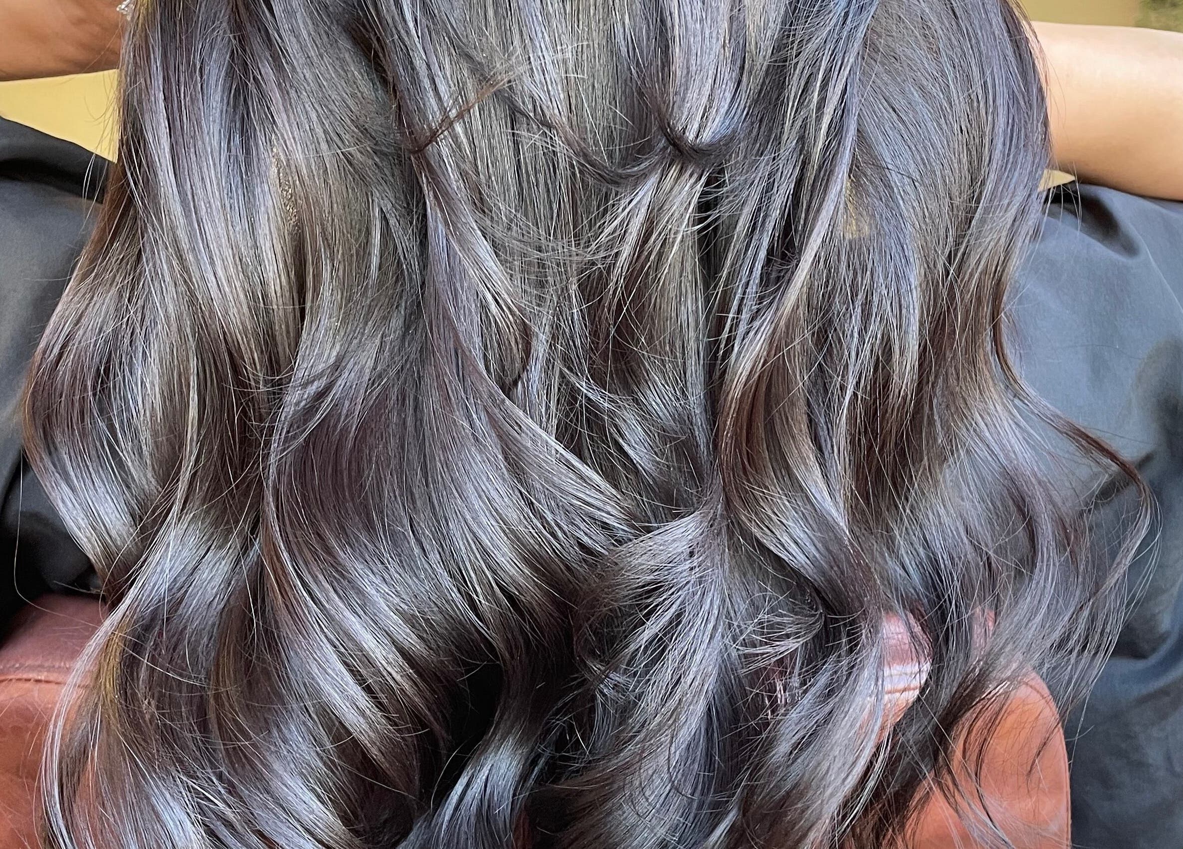 Lustrous wavy hair styled at Just Grace Hairdressing, Northampton, England, GB for a sleek, elegant look.