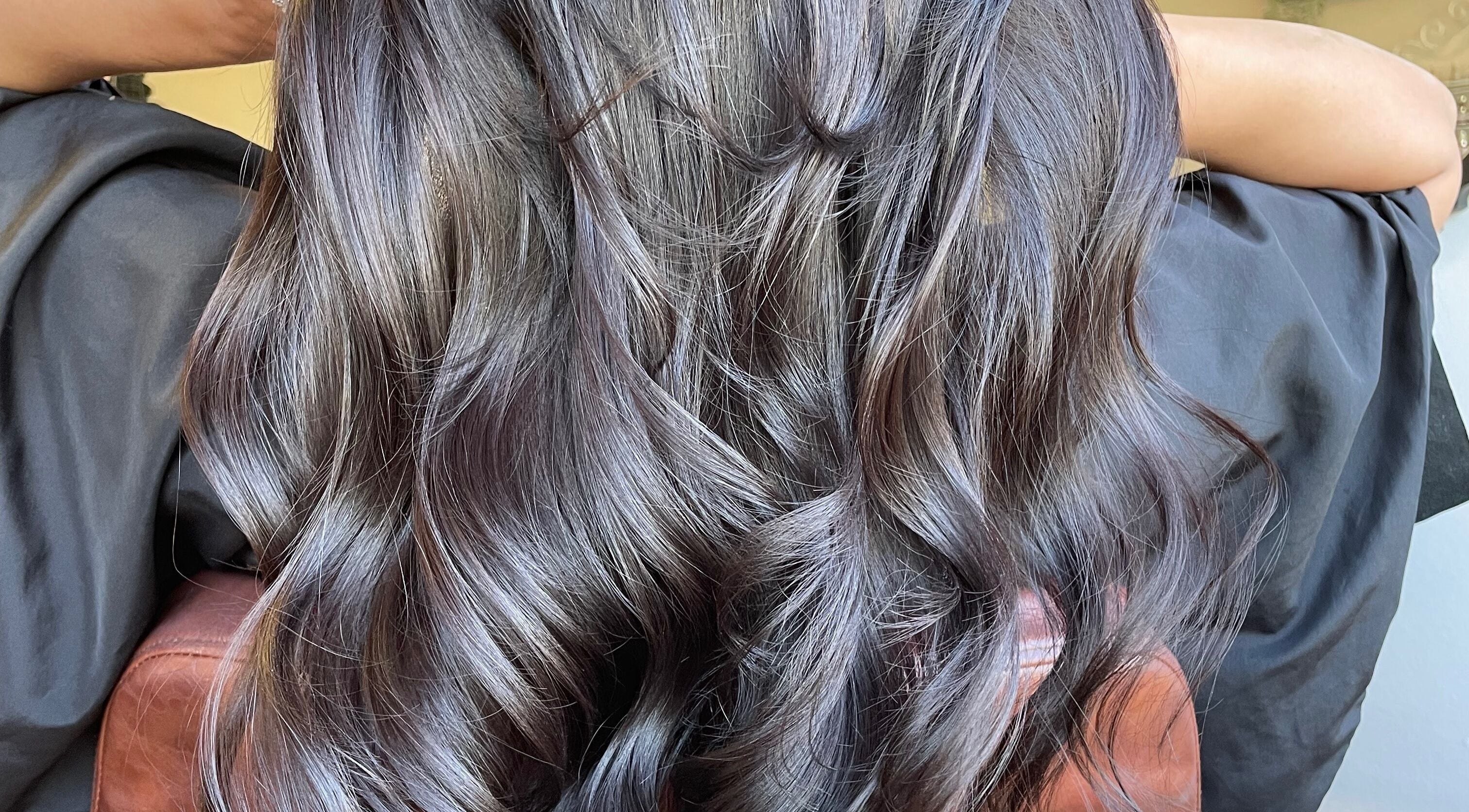 Lustrous wavy hair styled at Just Grace Hairdressing, Northampton, England, GB for a sleek, elegant look.