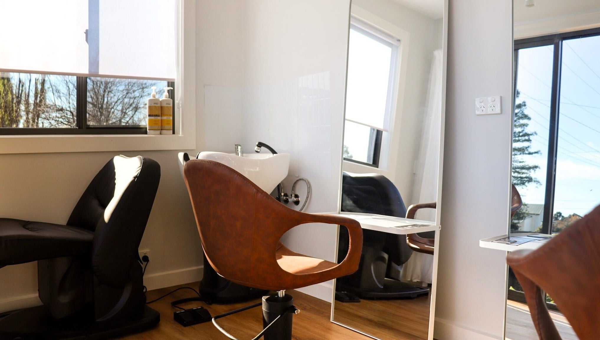 Modern salon chair and wash basin at Smart Hair Studio, Terang, Victoria, AU with sunlit ambiance.