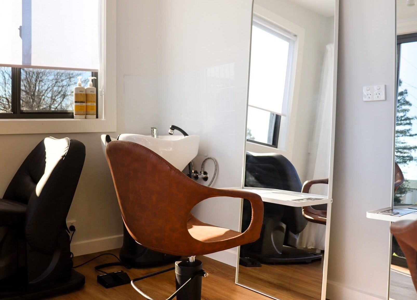 Modern salon chair and wash basin at Smart Hair Studio, Terang, Victoria, AU with sunlit ambiance.