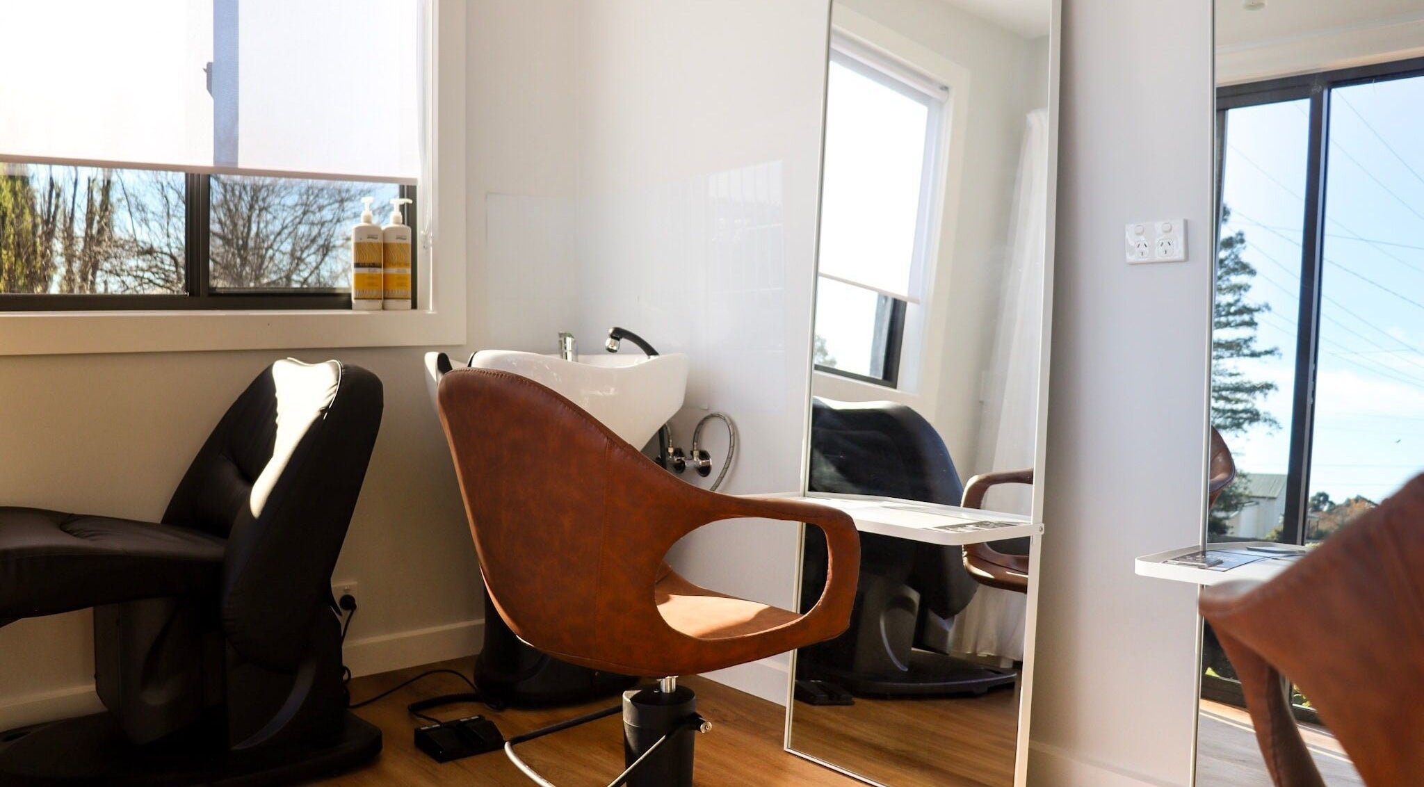 Modern salon chair and wash basin at Smart Hair Studio, Terang, Victoria, AU with sunlit ambiance.