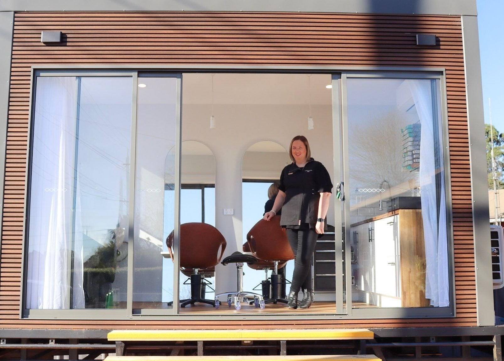 Exterior view of Smart Hair Studio, Terang, Victoria, AU, showcasing stylish salon chairs and glass facade.