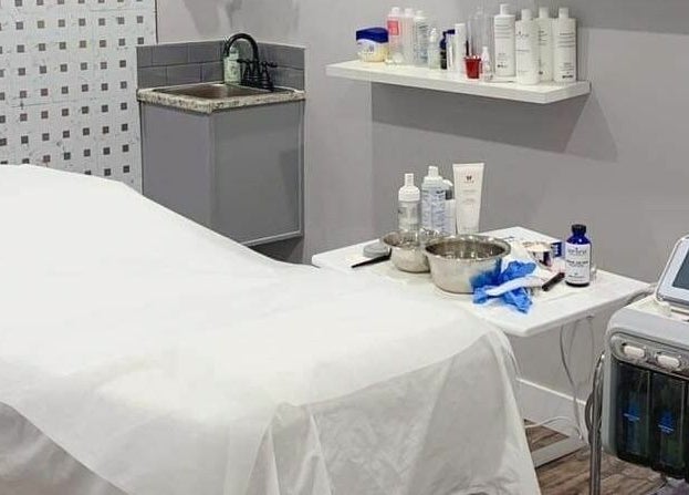 Luxurious spa room at MLux Spa & Nails Lounge in Red Deer, Alberta, CA featuring a treatment bed and equipment.