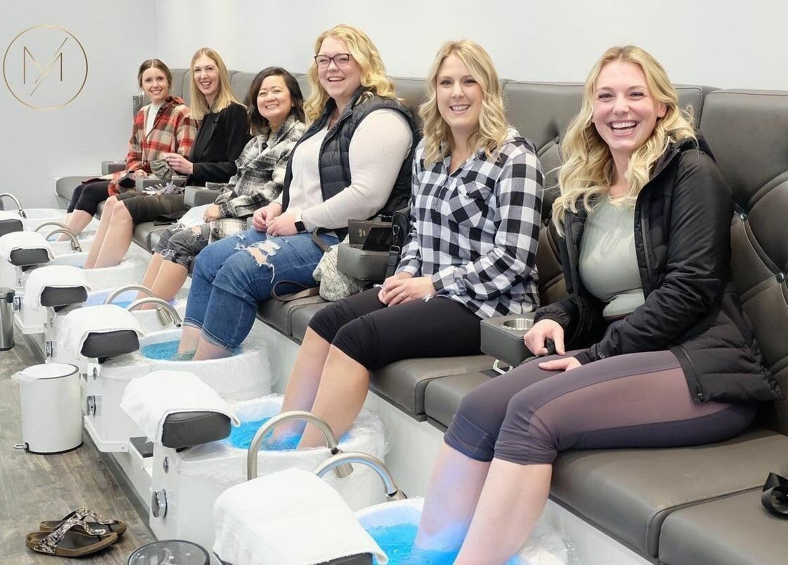 Group enjoying pedicures at MLux Spa & Nails Lounge, Red Deer, Alberta, CA with relaxing ambiance.