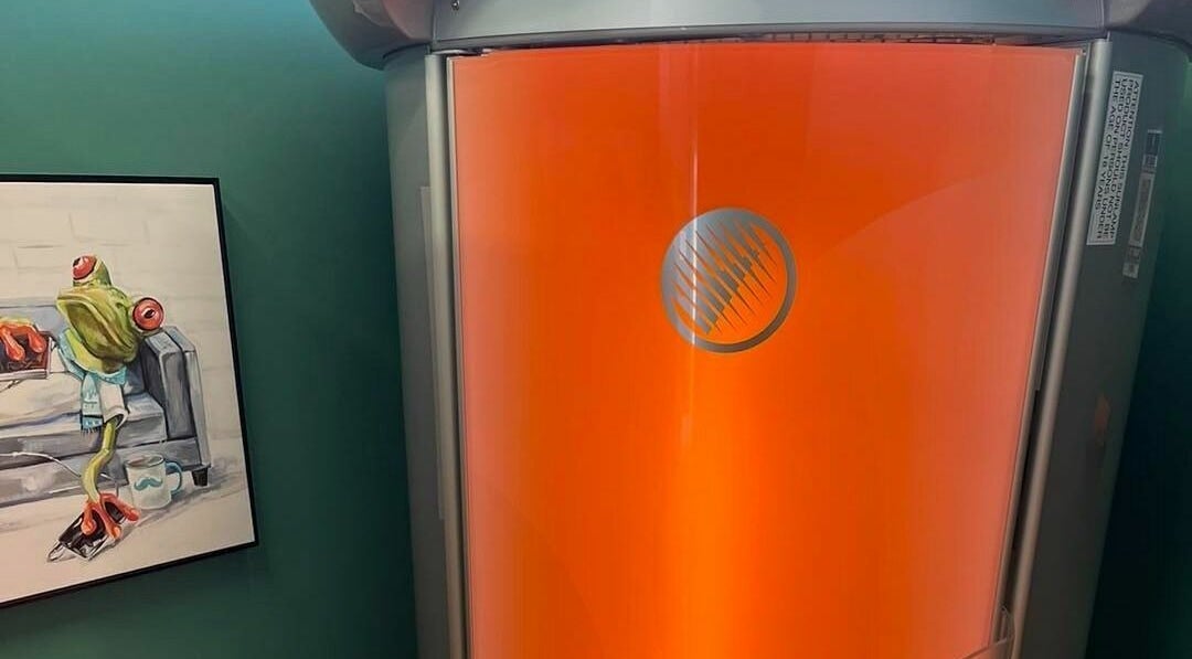 Vibrant tanning booth at Industry Salon and Tanning in Chatham-Kent, Ontario, CA with modern decor.