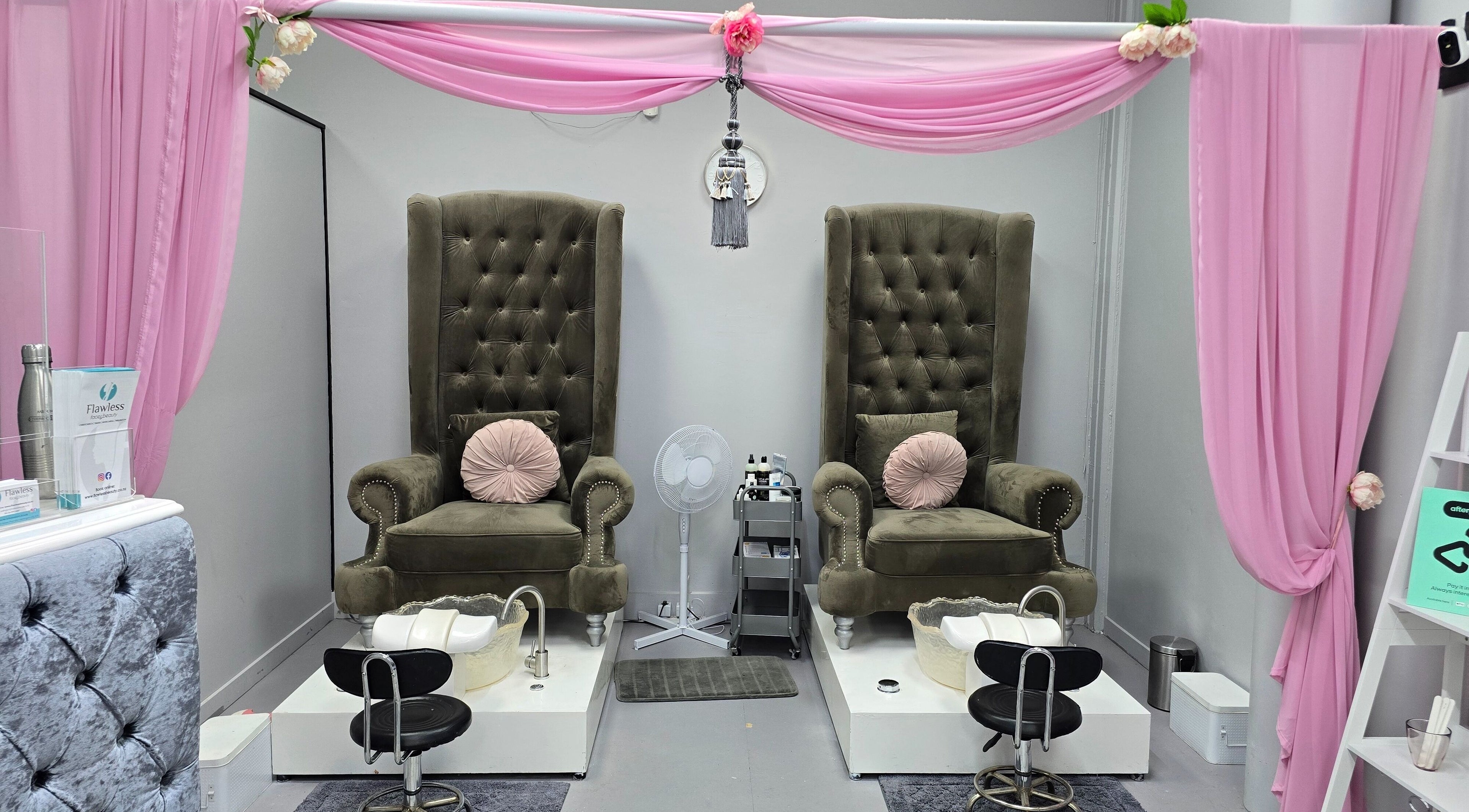 Elegant pedicure chairs at Flawless Face and Beauty Wellington, Wellington, NZ, surrounded by soft pink drapery.