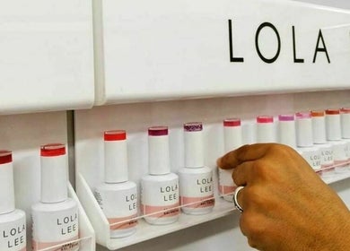 Hand selecting nail polish at Flawless Face and Beauty Wellington, NZ. Various shades neatly arranged.