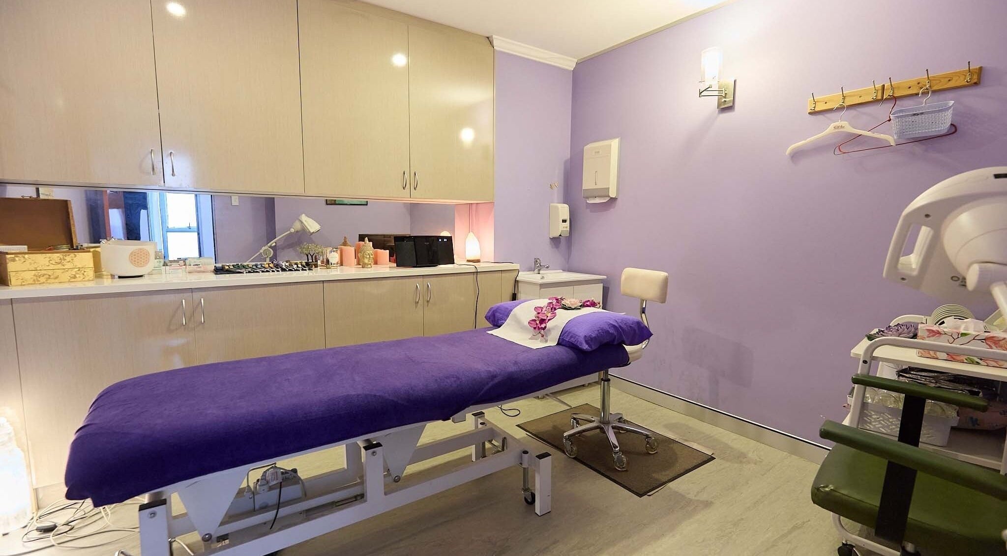 Relaxing treatment room at Acupuncture Syd CBD, Sydney, New South Wales, AU with purple bed and calming ambiance.