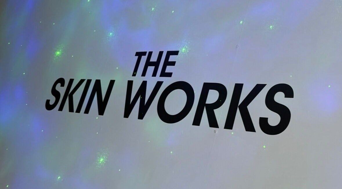 'The Skin Works' logo on a glowing wall at Saint Helens, England, GB venue.
