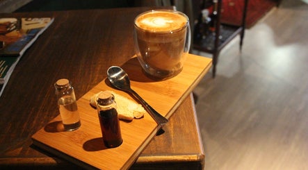 Cozy drink setting at The Male Room, East London, Eastern Cape, ZA with a latte and spice vials.