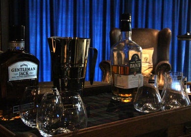 Sophisticated whiskey lounge at The Male Room, East London, Eastern Cape, ZA, showcasing premium bottles and glasses.