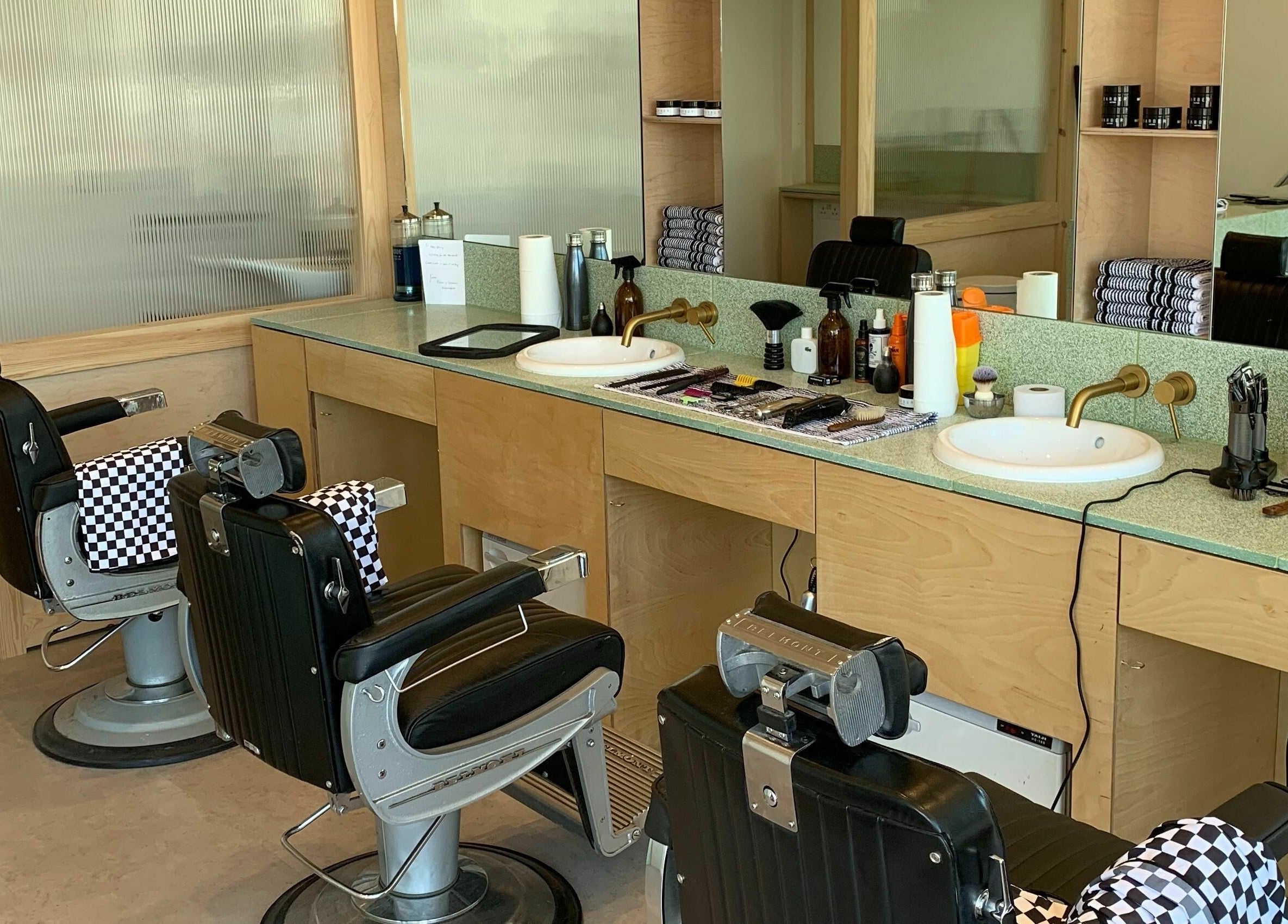 Modern barber chairs at Barber and Frank Kemptown in Brighton, England, GB, with tools neatly arranged.